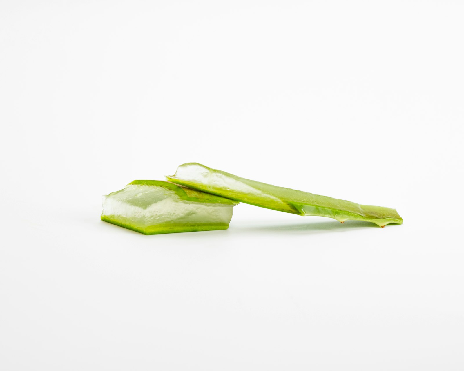 Fresh celery stalks with leaves on a white surface